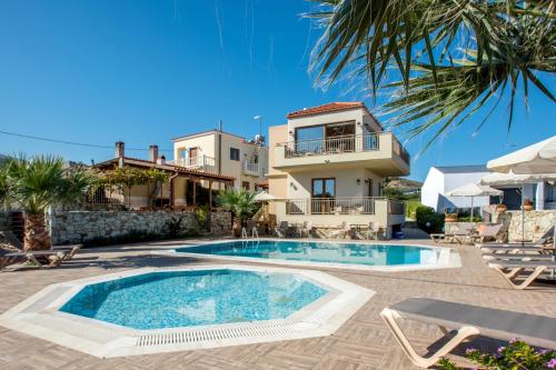 a villa with a swimming pool in front of a house at Kladissos Villa in Agia Pelagia
