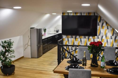 a kitchen with a table and a television on a wall at Apartament Orły air conditioning in Orły