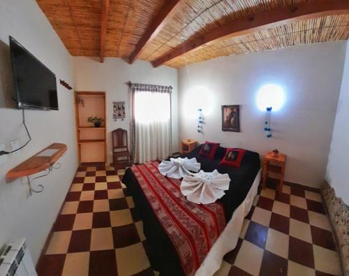 ein Schlafzimmer mit einem Bett und einem karierten Boden in der Unterkunft Hosteria Andina in Maimará