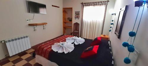 Hosteria Andina في مايمارا: غرفة نوم بها سرير عليه زهور