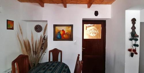 um quarto com uma porta, uma mesa e uma cadeira em Hosteria Andina em Maimará