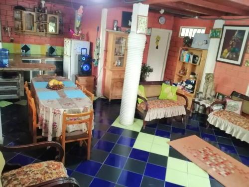 a living room with a table and a kitchen at Agradable granja cerca a un río de agua fresca. in Archidona