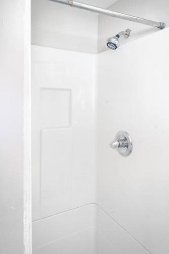 a shower in a bathroom with a shower head at Charming Carriage Cottage from 1920s in Oklahoma City
