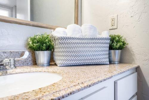 a bathroom counter with a sink and a basket of towels at Historic 1920s Brick Beauty in Medical District in Oklahoma City