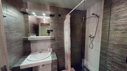 uma casa de banho com um lavatório e um chuveiro em Ride Pub Drienica em Drienica