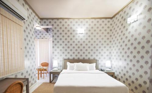 a bedroom with a bed and a table and chairs at Sonaar Haveli in Jaisalmer