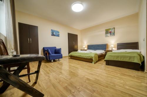 una habitación de hotel con 2 camas y una silla azul en Nine Hotel en Tiflis