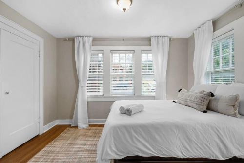 una camera da letto con un grande letto bianco e finestre di Step Back in Time Historic Details Ideal Location a Oklahoma City