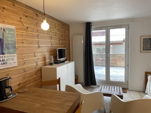 een woonkamer met houten wanden en een tafel en stoelen bij Appartement avec terrasse in Les Deux Alpes