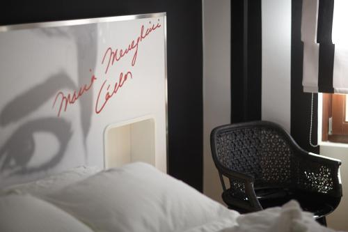 a bedroom with a chair next to a bed at Veritas Boutique Art Hotel in Veria