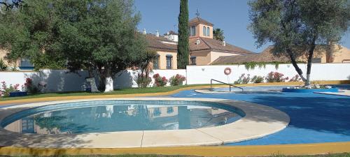 a swimming pool in front of a house at Apartamento Aljarafe in Valencina de la Concepción