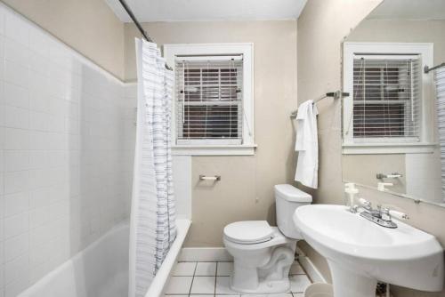 La salle de bains blanche est pourvue de toilettes et d'un lavabo. dans l'établissement Elegant and Historic Getaway Close to Everything, à Oklahoma City