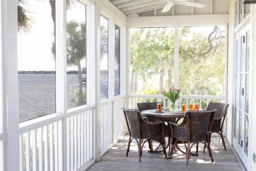 une terrasse couverte avec une table et des chaises dans l'établissement The Cottages on Charleston Harbor, à Charleston