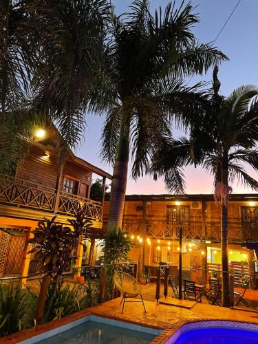 um resort com piscina, palmeiras e um edifício em Tierra Viva em Puerto Iguazú