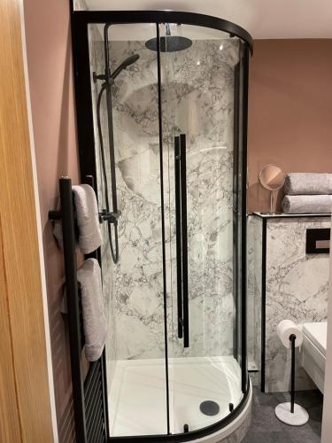 a shower with a glass door in a bathroom at Luxury flat in Totnes in Totnes