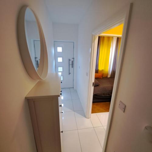a hallway with a mirror and a room with a bed at Lovely and Modern Groundfloor 1 Single Bedroom Condo with Netflix, Tea/Coffee/Biscuits in Bristol