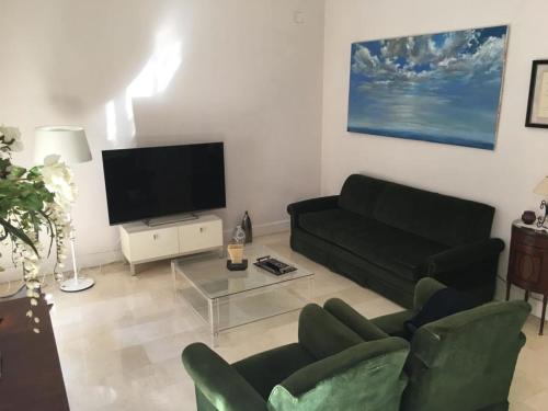 sala de estar con sofá negro y TV en CHIC e CLASSIC, en Alicante