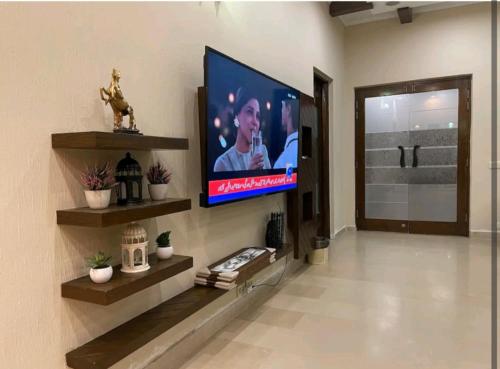 a living room with a flat screen tv on a wall at Hotel Grand Lahore in Lahore