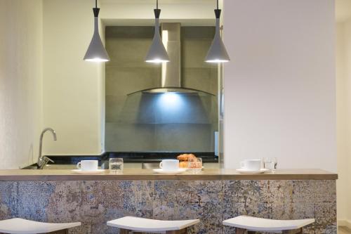 una cocina con una barra con 4 taburetes en Zafiro Flat by Serendipia Turismo, en Santiago de Compostela