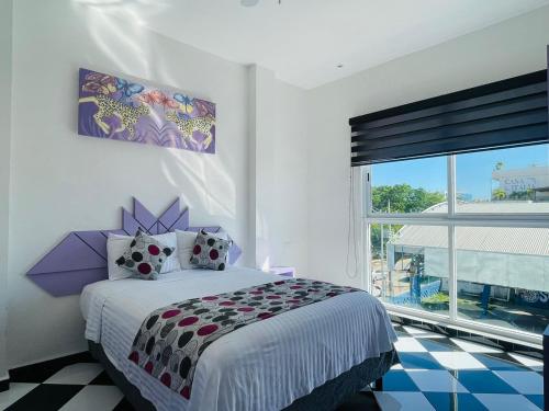 a bedroom with a bed and a large window at WINDAY HOTEL - Cerca 5a Avenida in Playa del Carmen