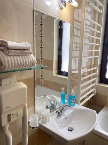 a bathroom with a sink and a mirror at HQ Apartment Flora Violet in Borovets