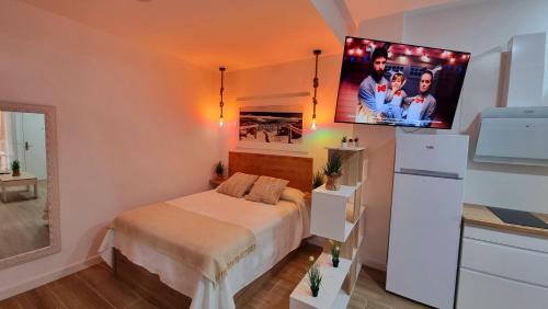 um quarto com uma cama e uma televisão na parede em Vivienda Turística Playa El Portil em El Portil