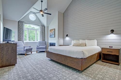 - une chambre avec un lit, une télévision et une chaise dans l'établissement Pocono Mountain Villas by Exploria Resorts, à East Stroudsburg
