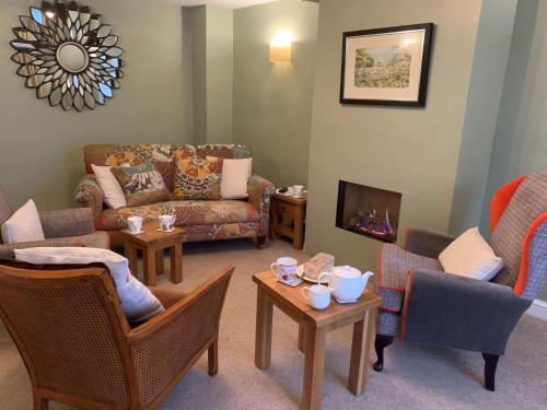 a living room with couches and chairs and a fireplace at Centre Chipping Campden - 3 Bedroom Cottage for 5 in Chipping Campden