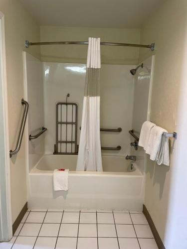 y baño con bañera y cortina de ducha. en Econo Lodge Inn & Suites Sweetwater I-20 en Sweetwater