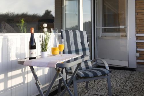 a table with two glasses and a bottle of wine at Frauenpreiß Ferienwohnungen in Cuxhaven