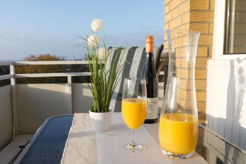 two glasses of orange juice and bottles of wine on a table at Frauenpreiß Ferienwohnungen in Cuxhaven