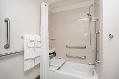 a bathroom with a toilet and a shower with towels at Candlewood Suites Pueblo, an IHG Hotel in Pueblo