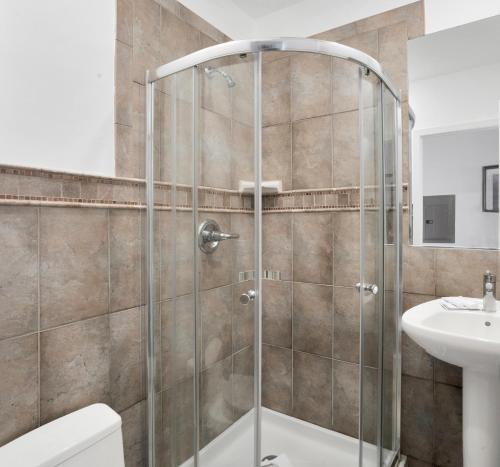a shower stall in a bathroom with a toilet and a sink at The Hermitage at Napeague in Amagansett