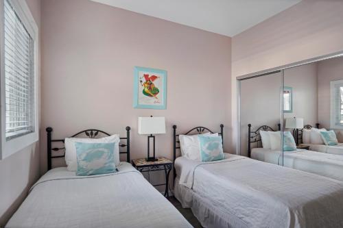a bedroom with two beds and a mirror at The Hermitage at Napeague in Amagansett