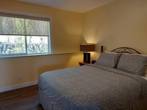 1 dormitorio con cama y ventana grande en Relaxing 3bdr 2bth Home with Gorgeous View, en Sechelt