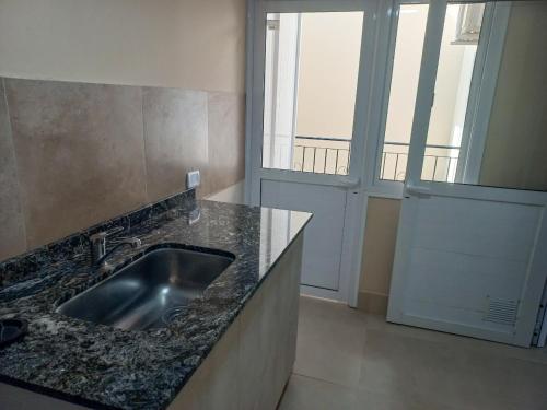 a kitchen with a sink and a large window at Departamento Alberdi in San Pedro de Jujuy