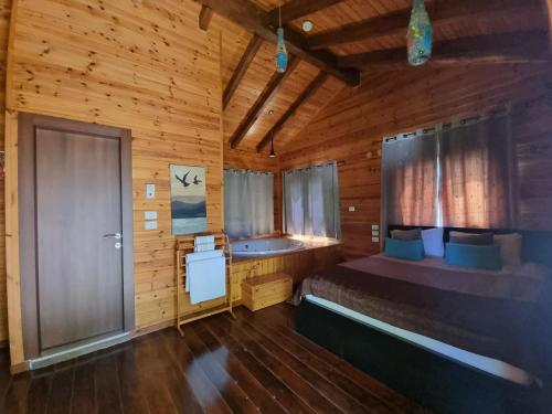 una camera con un letto in una cabina di legno di A Place To Dream a Ẕippori