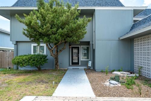 a house with a tree in the front yard at Edgewater Escape in Rockport