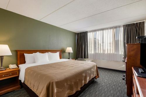 um quarto de hotel com uma cama grande e uma janela em Quality Inn Joliet em Joliet