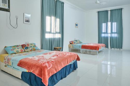 1 Schlafzimmer mit 2 Betten in einem weißen Zimmer in der Unterkunft Salem Fish Guest House in Ras al-Hadd