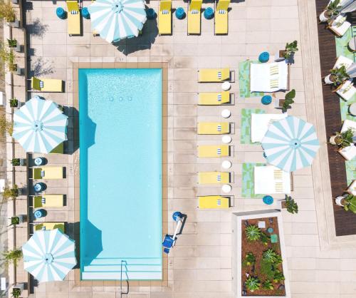 einen Blick über einen Pool mit Sonnenschirmen in der Unterkunft Hotel Indigo - Los Angeles Downtown, an IHG Hotel in Los Angeles