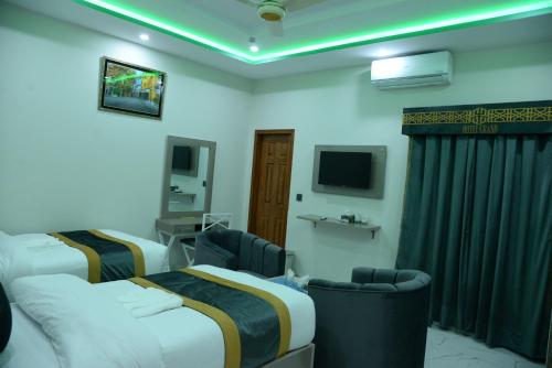 a hotel room with two beds and a tv at Hotel Grand Lahore in Lahore