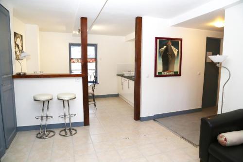 a living room with a bar and stools at Appartement du Port de Honfleur in Honfleur