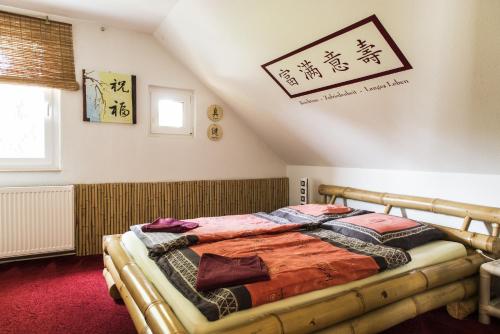 ein Schlafzimmer mit einem Bett mit einem Schild an der Wand in der Unterkunft Ferienwohnung Casa Casimir mit Elbblick, Balkon und großen Garten in Dresden