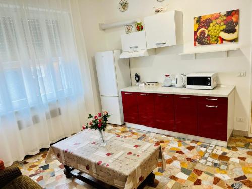 una cocina con armarios rojos y una mesa con flores. en Le Maschere, en Mestre