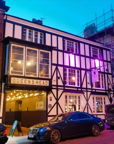 a black and white building with a car parked in front at The Queens Head in Ashby de la Zouch