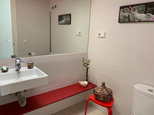 een badkamer met een wastafel, een spiegel en een kruk bij Atico En Las Negras in Las Negras