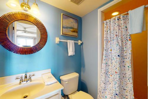 ein Badezimmer mit einem Waschbecken, einem WC und einem Spiegel in der Unterkunft Happy Days in St. George Island