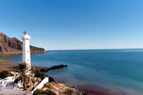 a lighthouse on a beach next to a body of water at Casa Morada in San Felipe