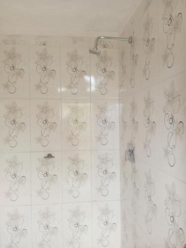 a bathroom with a shower with silver swirls on the wall at Cómo en casa in Tarija